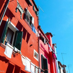 Trocknende Wäsche vor roten Häusern auf Burano