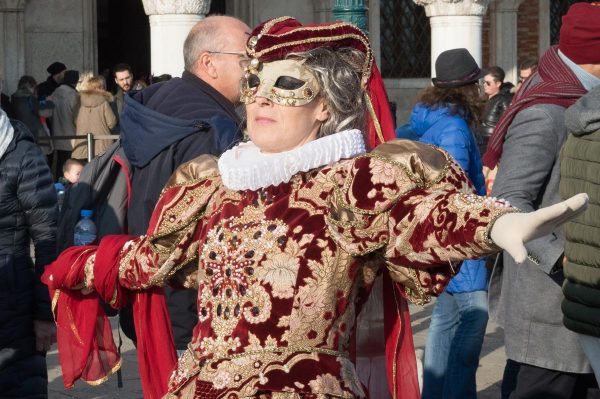 Women with spread arms in Venice Carnival